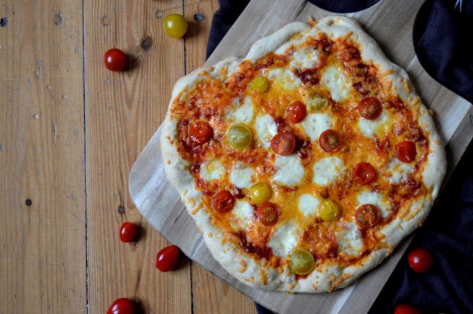 Einfache Pizza mit Mozzarella, Cheddar und Tomaten